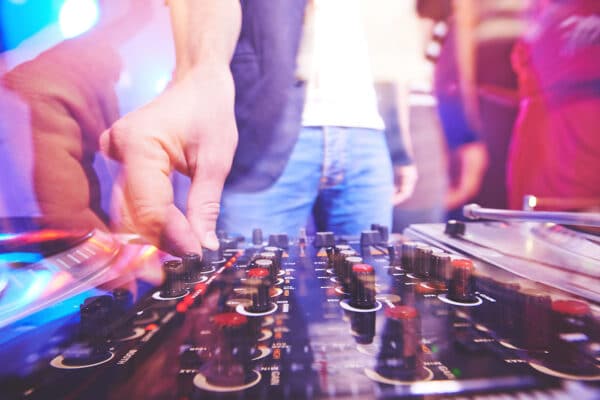 Hand of dj adjusting sound